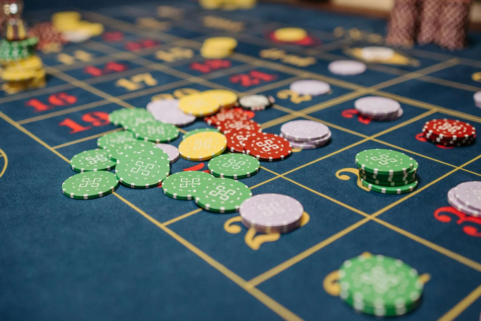 A roulette table in working condition - chips arranged across a navy Velvetine layout